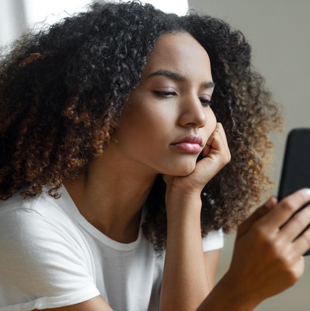 woman looking at mobile phone screen