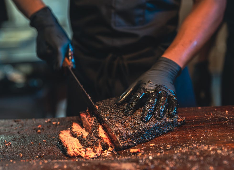 a bbq chef prepares a delicious serving of smoked brisket