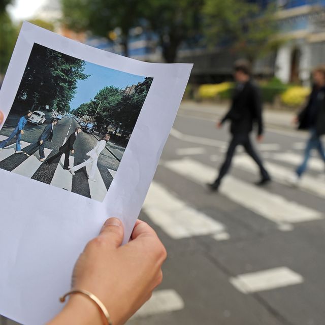A print of the famous Abbey Road Beatles record cover is pictured at the same pedestrian crossing on Abbey Road, in north London
