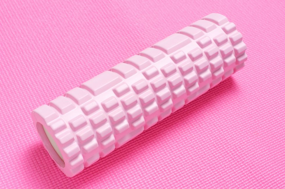 massage foam roller on pink sports mat close up side view