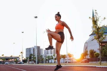 woman warming up before run in urban environment