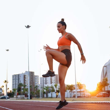 woman warming up before run in urban environment woman warming up before run in urban environment