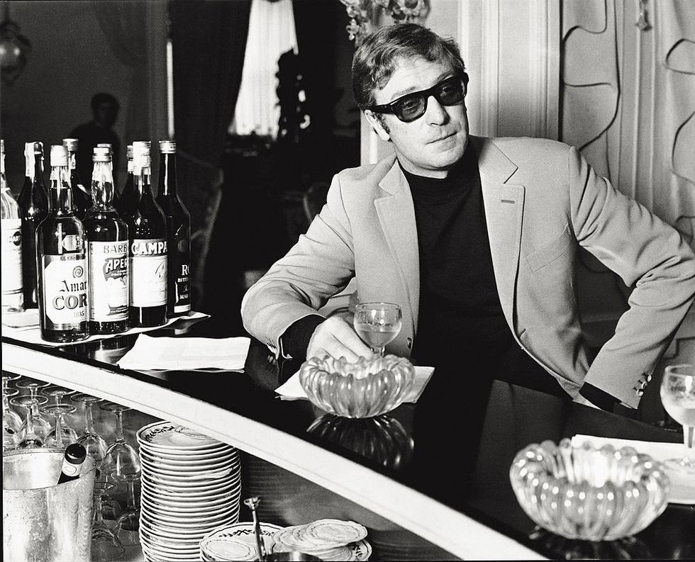 british actor michael caine, leaning against a counter, having a drink turin, august 1968 photo by mondadori via getty images