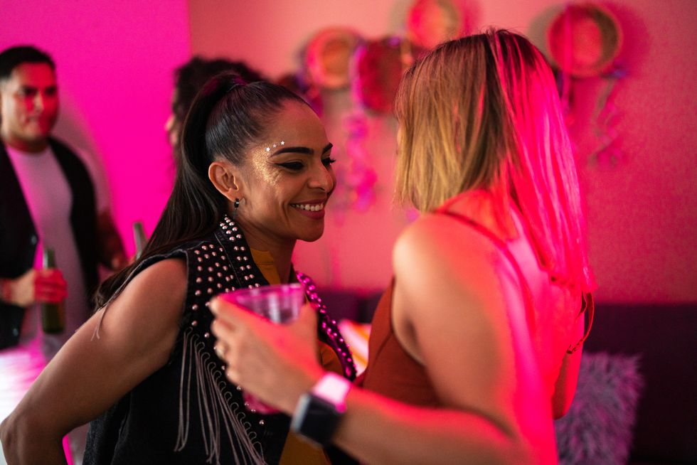 two lesbian mid adult women flirting at a party