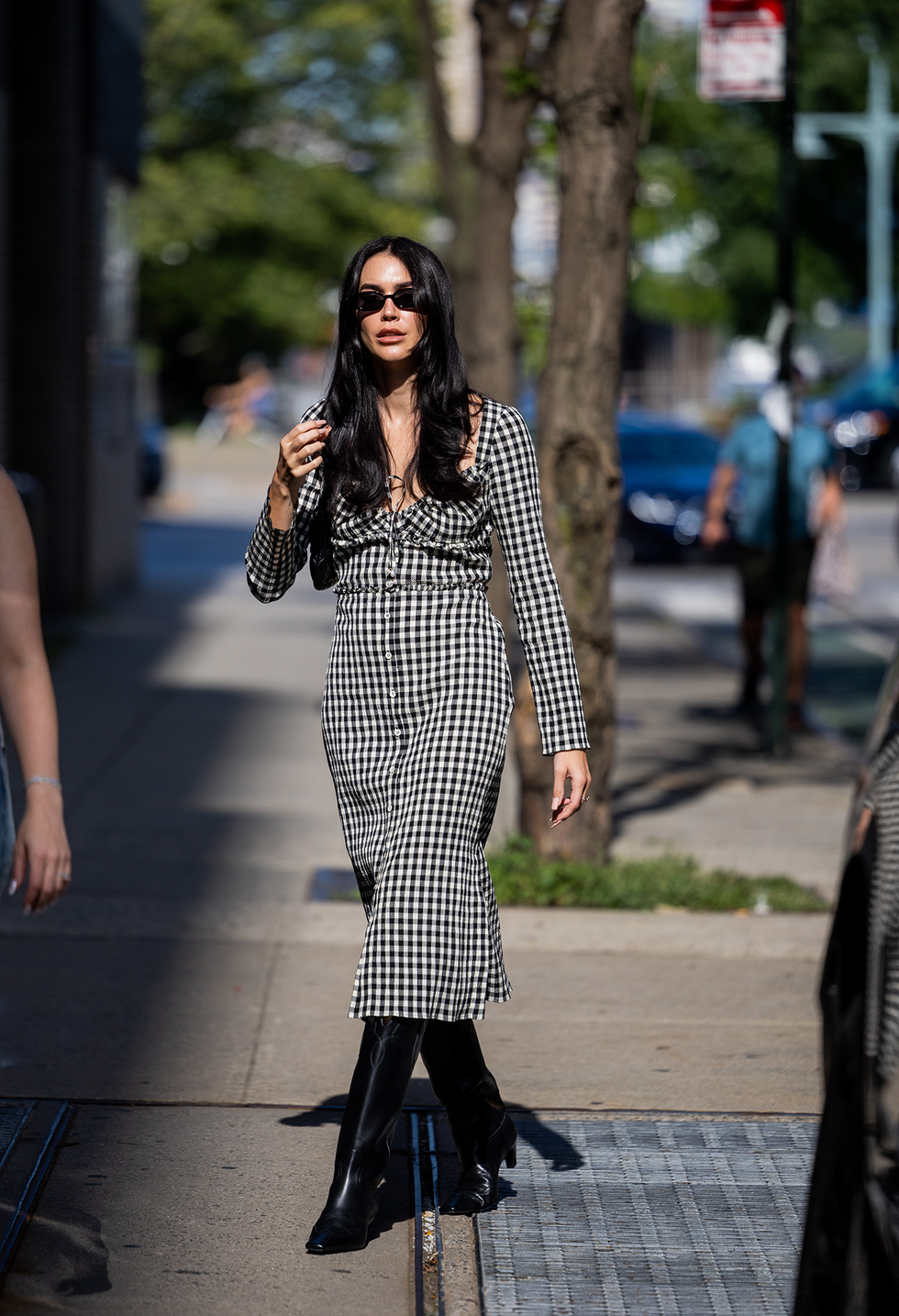 New York, New York, 10 september: Brittany Xavier draagt ​​een zwart-wit geblokte jurk en zwarte laarzen buiten Altuzarra op 10 september 2022 in New York City. (Foto: Christian Vierig/Getty Images)