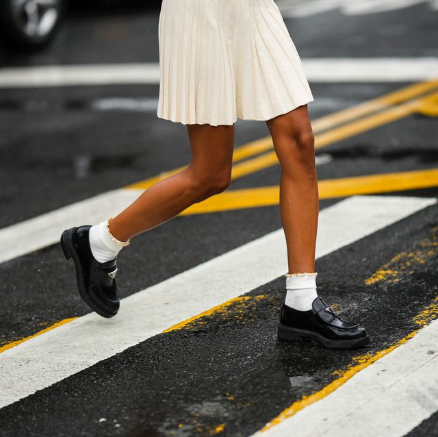new york, new york september 11 a guest wears a white latte embossed ribbed short skirt, white socks, black shiny varnished leather loafers from prada, gold and silver rings, outside khaite, during new york fashion week, on september 11, 2022 in new york city photo by edward berthelotgetty images