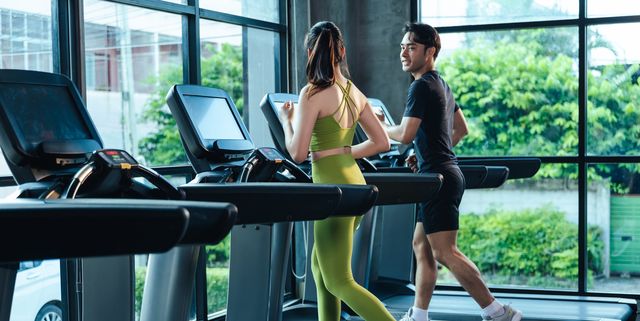 together asian man and woman healthy in sportswear cardio exercise jogging on a treadmill in fitness gym sport people workout indoor for good health healthy lifestyle concept