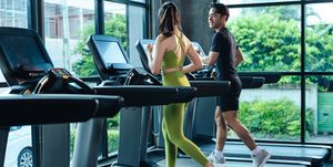 together asian man and woman healthy in sportswear cardio exercise jogging on a treadmill in fitness gym sport people workout indoor for good health healthy lifestyle concept