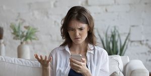 vrouw leest nieuws op telefoon en is geschrokken, begrijpt het niet