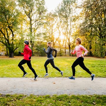 three caucasian women in sports gear running through a non urban area