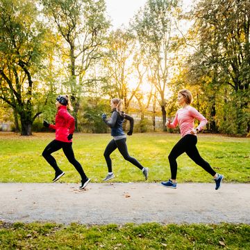 three caucasian women in sports gear running through a non urban area