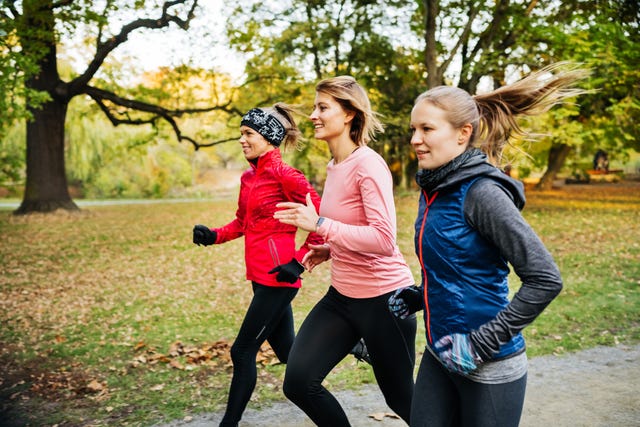 three caucasian women in sports gear running through a non urban area