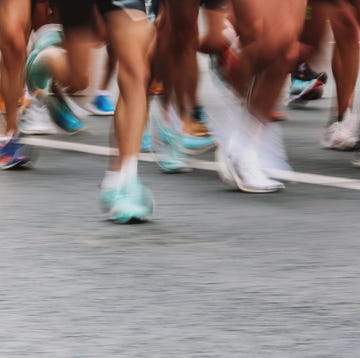 Low Section Unknown People Running Marathon, Defocused Sports Background sports activities background people running marathon distance at the city street banner horizontal, ambient light, copy space, blurred motion