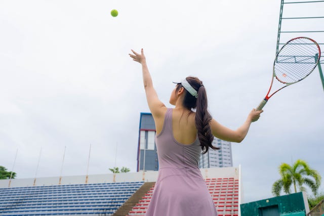female tennis player serving on outdoor tennis court