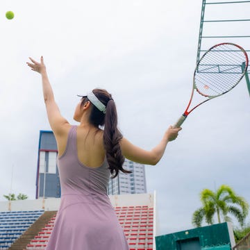 I played the best tennis match of my life thanks to yerba mate female tennis player serving on outdoor tennis court