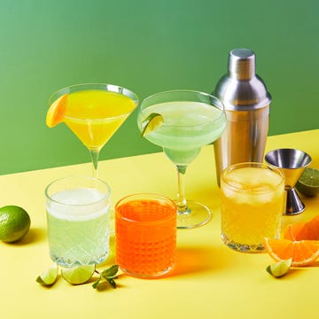 Multi-colored cocktails in glasses of different shapes on colored backgrounds with hard shadows multicolored cocktails in glasses of different shapes with orange and lime on colored backgrounds with hard shadows