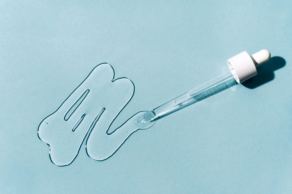 pipette with liquid gel or serum on pastel blue background concept of hyaluronic acid, polyglutamic acid or serum with peptides, ceramides, retinol molecules