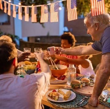 Multi-generation family having dinner outdoors on an American national holiday a multi generation multiracial family having dinner outdoors on an american national holiday