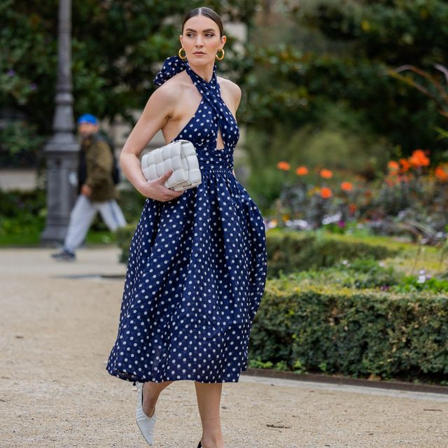 paris, france october 03 a guest wears navy dress with white dots print, bottega veneta bag, white black heels outside zimmermann during paris fashion week womenswear springsummer 2023 day eight on october 03, 2022 in paris, france photo by christian vieriggetty images