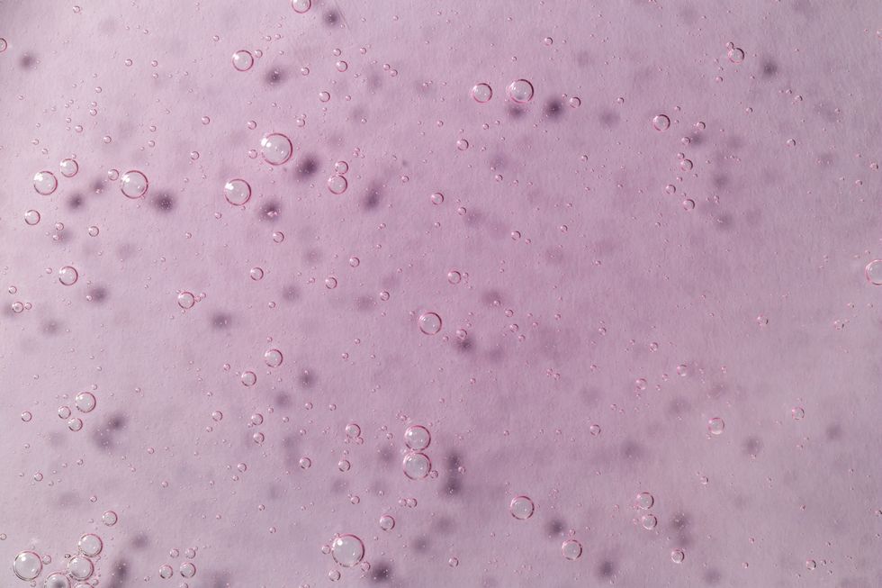 light pink textured gel background with bubbles close up the concept of cosmetic, medical and other laboratory research selective focus