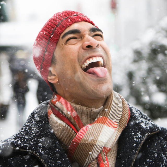 man catching snowflakes with tongue