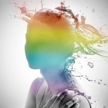 girl with water splashing on her face in rainbow colors