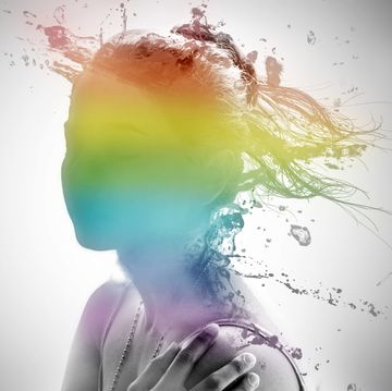girl with water splashing on her face in rainbow colors
