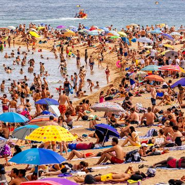 crowds of tourist on barceloneta beach, barcelona, spain