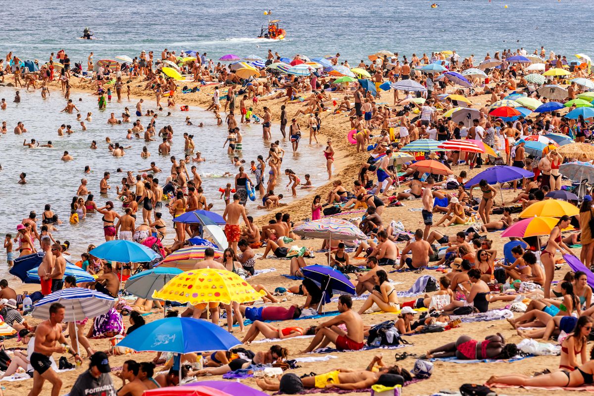 crowds of tourist on barceloneta beach, barcelona, spain
