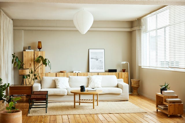 sofa with coffee table by window in living room picture frame is on cabinet at home interior of modern bright apartment