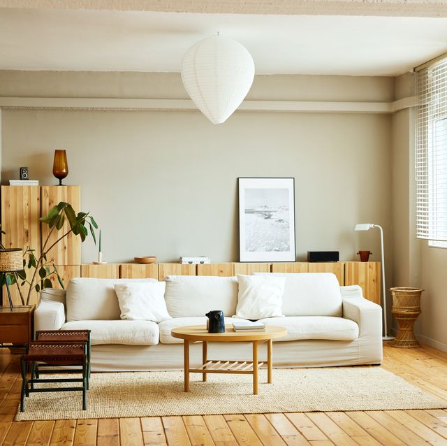 sofa with coffee table by window in living room picture frame is on cabinet at home interior of modern bright apartment
