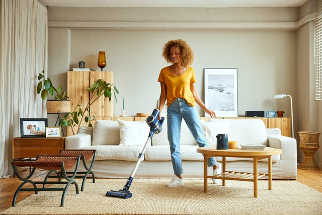 mujer limpiando con una aspiradora sin cable