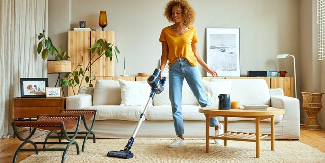 Mujer limpiando con una aspiradora sin cable mujer limpiando con una aspiradora sin cable