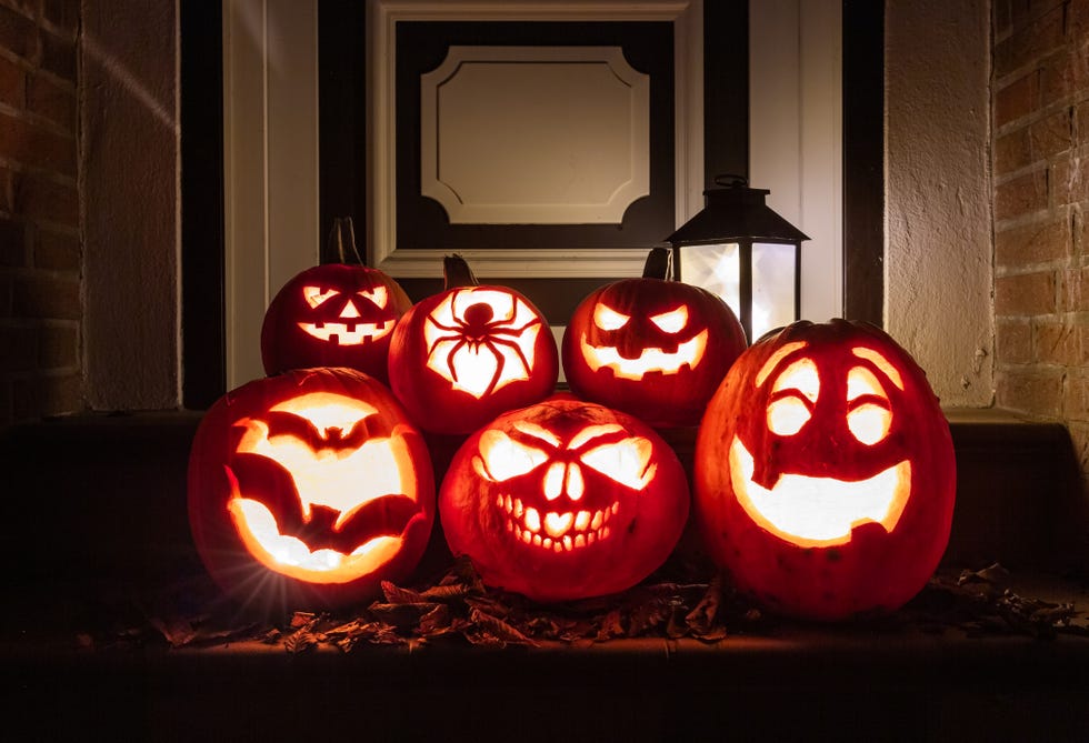 night shot of illuminated pumpkins in front of a house
