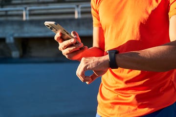 close up of the hands of a sportsman holding his smartphone and smartwatch. device synchronization. sport and technology concept.