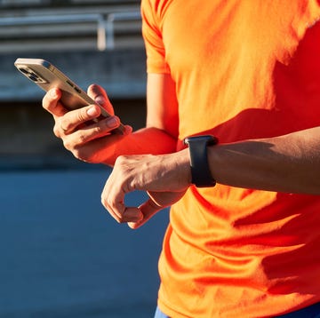 Close up of the hands of a sportsman holding his smartphone and smartwatch. Device synchronization. Sport and technology concept. close up of the hands of a sportsman holding his smartphone and smartwatch. device synchronization. sport and technology concept.