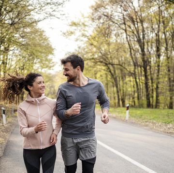 happy athletic couple having fun while running in spring day