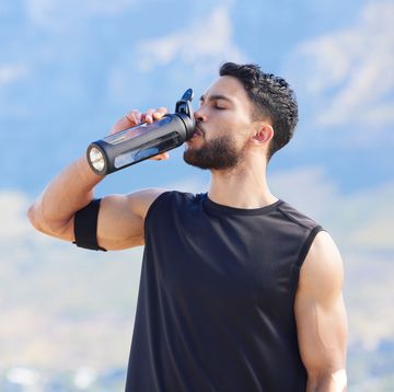 fitness, blue sky and man drinking water from bottle to refresh and relax after workout, running or sports training cardio runner, exercise and thirsty young person with liquid drink for hydration