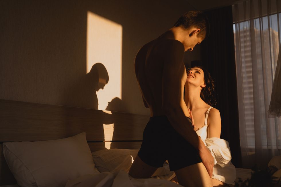 couple in love in the morning on the bed, lovers embrace passionately foreplay and wedding night passion and relationship concept