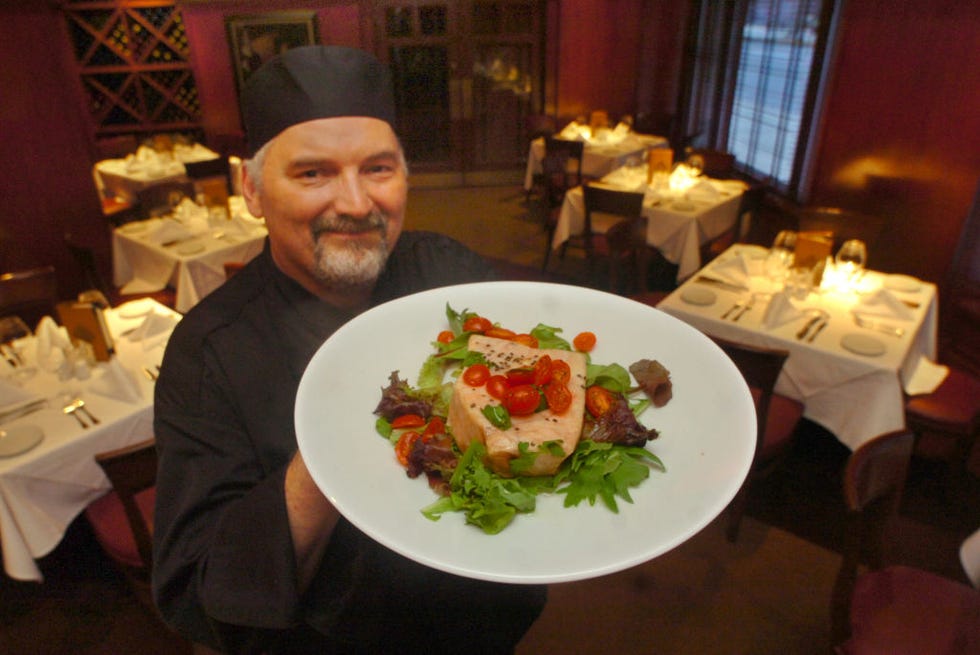 chef joe bartel with fish at flemings prime steakhouse portrait of bartel with hallibut and tarrigon and tomatoe vinagrette over mixed greens