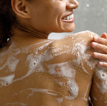 close up of african woman taking a shower with gel or shampoo foam in bathroom high quality photo