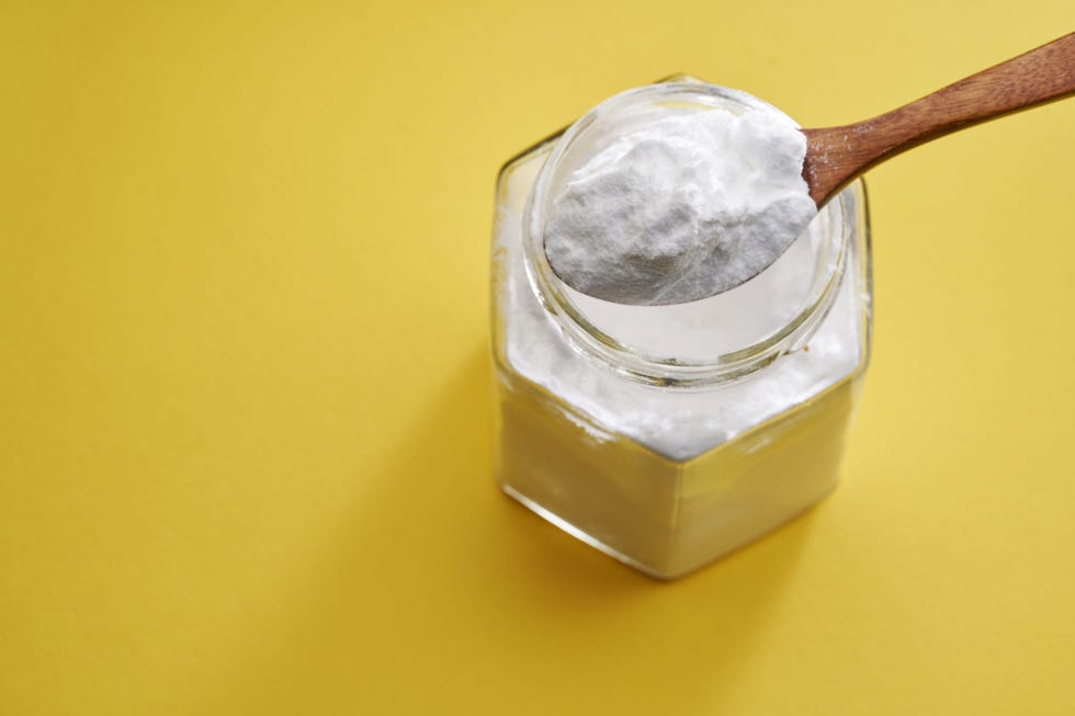 high angle view spoon of baking soda against yellow background