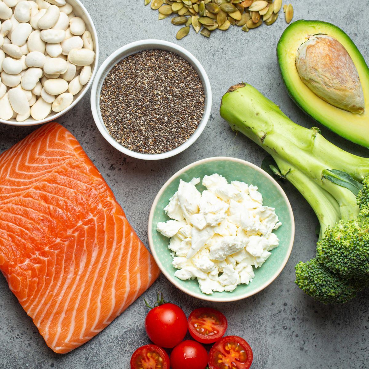 selection of healthy food products if a person have diabetes salmon fish, broccoli, avocado, beans, vegetables, seeds on grey background from above healthy diabetes diet