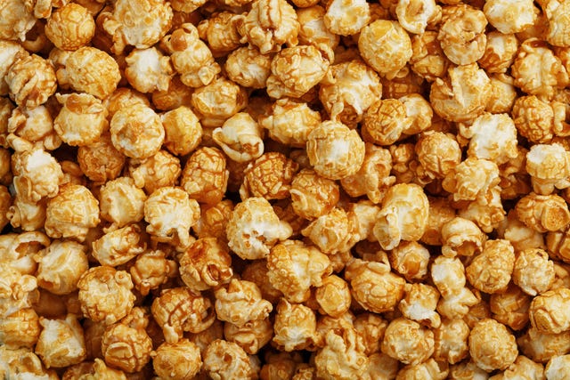 popcorn in caramel glaze close up as a background. delicious praise for watching movie movies, serial, cartoon. close up