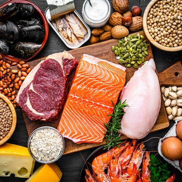 overhead view of a large group of food with high content of healthy proteins the composition includes salmon beef fillet, chicken breast, eggs, yogurt, mussels, chick peas, pistachios, cheese, brown lentild, beans, shrimps, canned tuna, pumpkin seeds, soybeans among others high resolution 42mp studio digital capture taken with sony a7rii and zeiss batis 40mm f20 cf lens