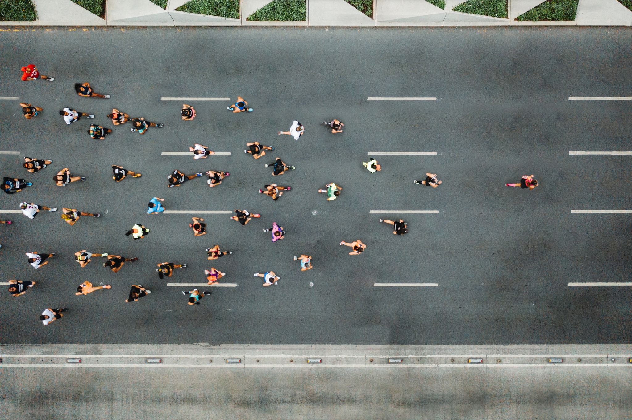 aerial view of marathon city runners one person leading marathon