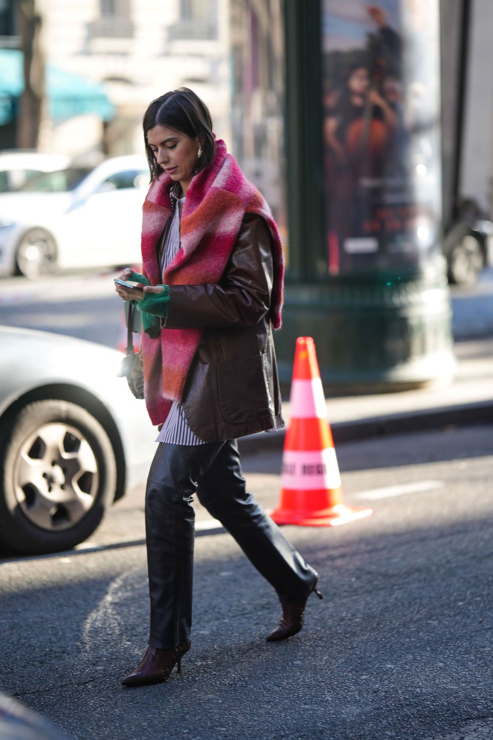 a woman in a pink coat walking on the street