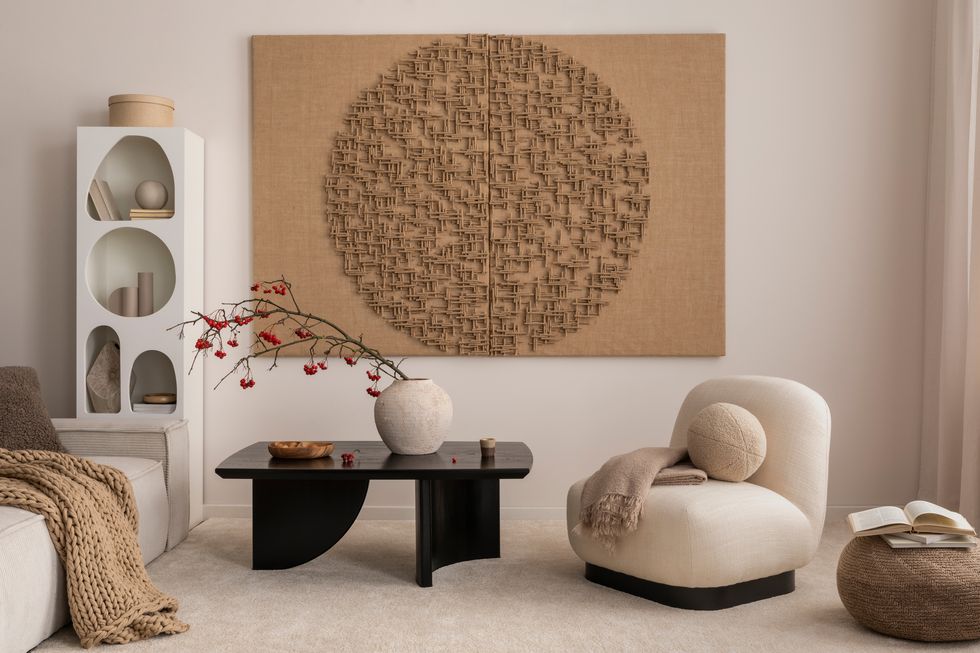 aesthetic composition of japandi living room interior with mock up poster frame, modern black coffee table, vase with rowan, rounded shapes armchair and personal accessories home decor template