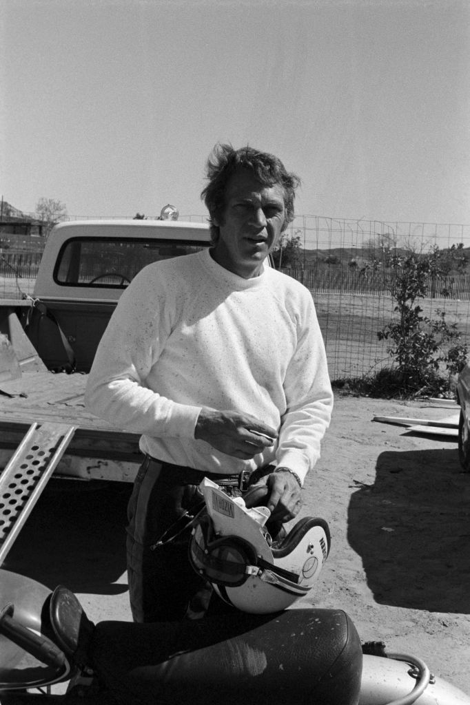 american actor steve mcqueen standing next to his motor cross bike outdoors and carrying a helmet he is dressed casually, wearing a white long sleeve shirt and dark tack pants photo was taken in los angeles on march 5, 1971 photo by fairchild archivepenske media via getty images