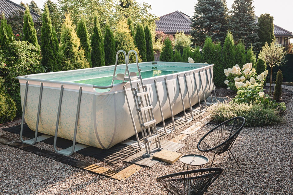 relaxation corner in the garden above ground, rectangular, rack frame swimming pool outdoor in the pebble gravel nook summer holiday vacation and recreation